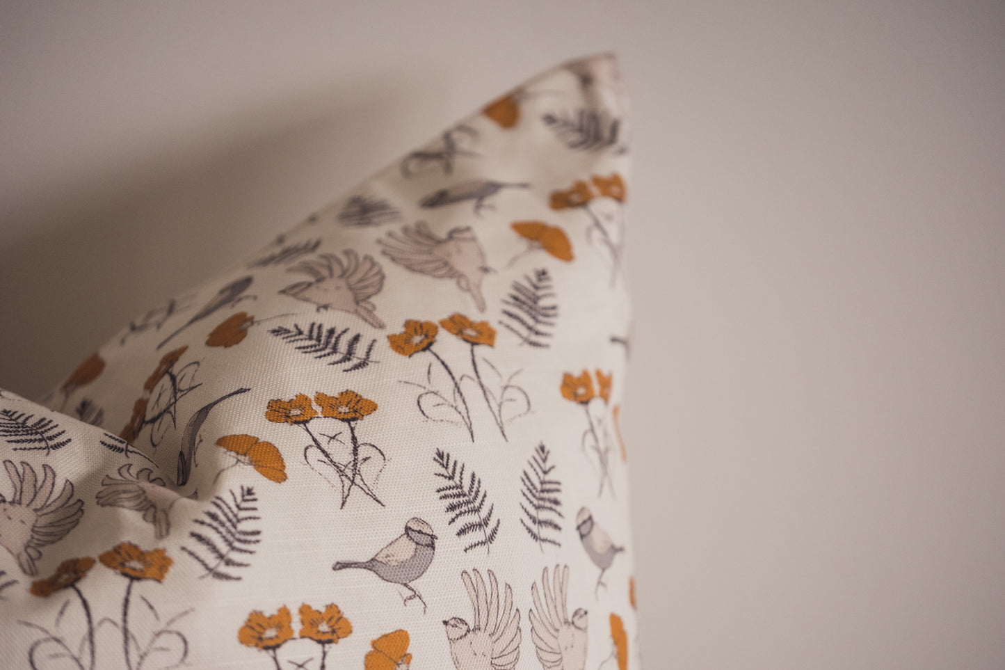 A close up of the Birdsong Cushion in Ochre by Lil & Dot.