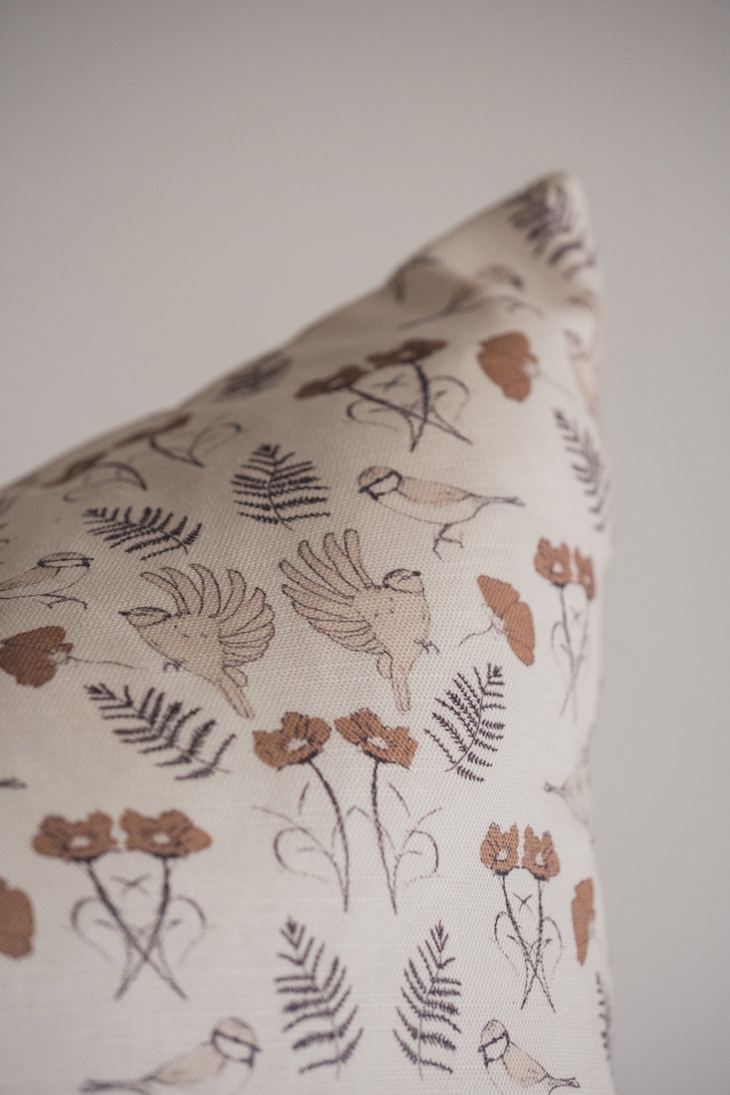 Image 2, a close up of the Lil & Dot hand illustrated Birdsong cushion in Mocha.