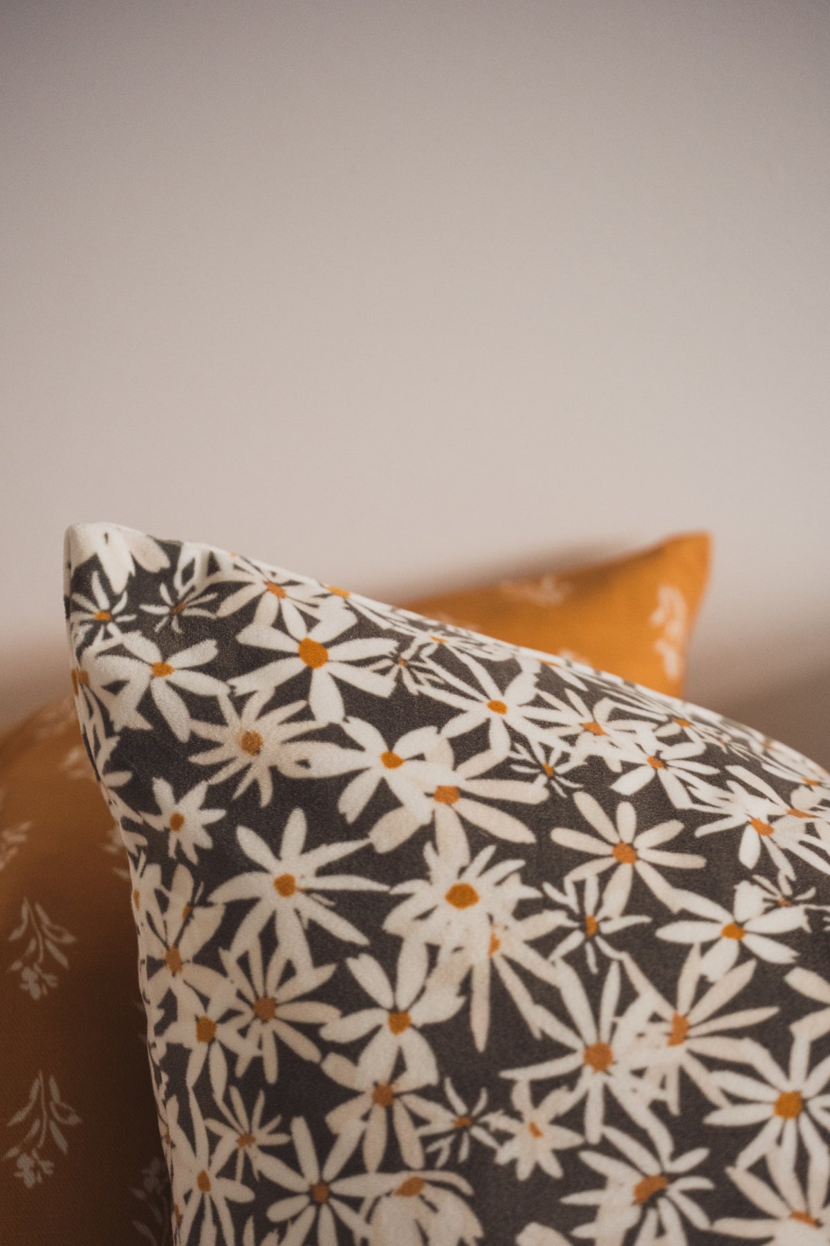 A close up of the Lil & Dot Daisy Cushion with the Soft Boom Cushion.