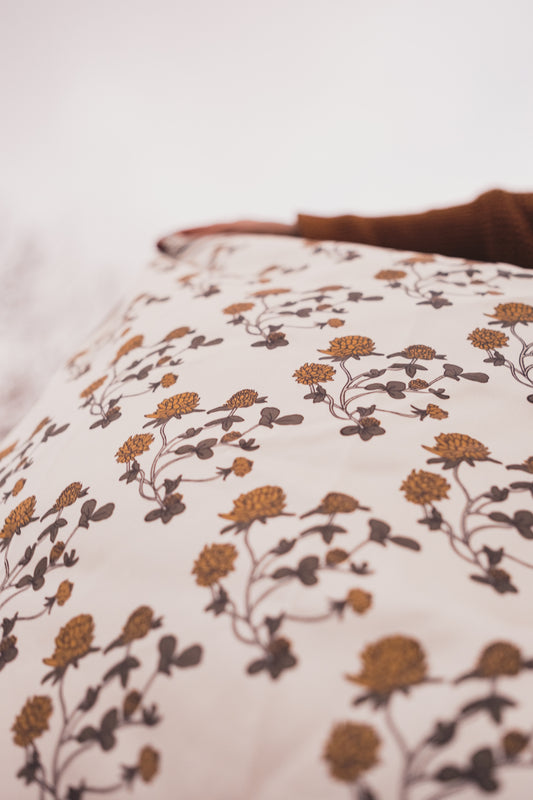 The Hand illustrated Clover Silk bandana blowing in the wind of a cloudy day.